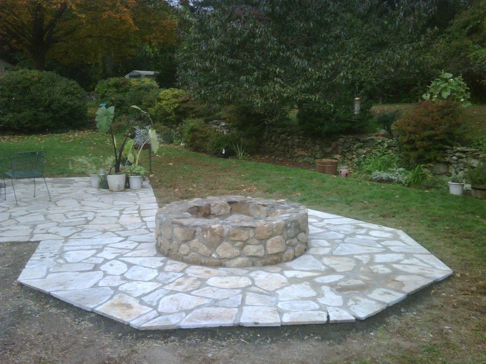 Stone fire pit set in a flagstone patio from a BREN job